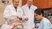 two faculty members and one resident consulting with patient